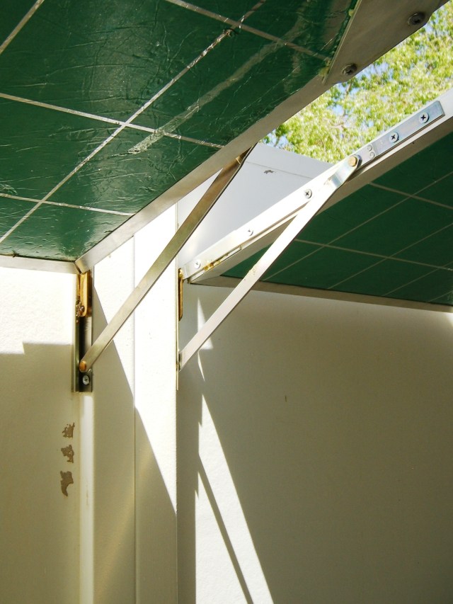 Whitco window stays that form hinges to support sun mirror panels in winter are set here to make the same panels give summer shade.